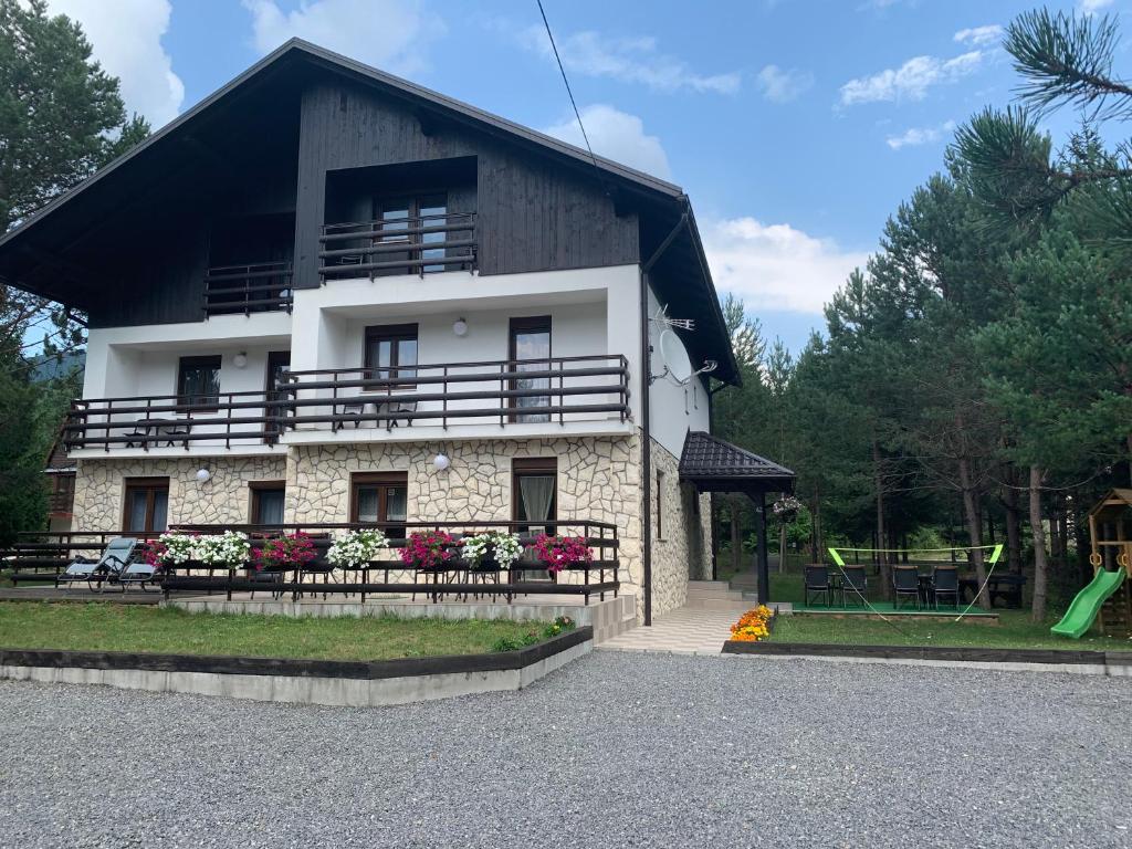 a large white building with a black roof at Apartmani Zeder Plitvička jezera in Rudanovac