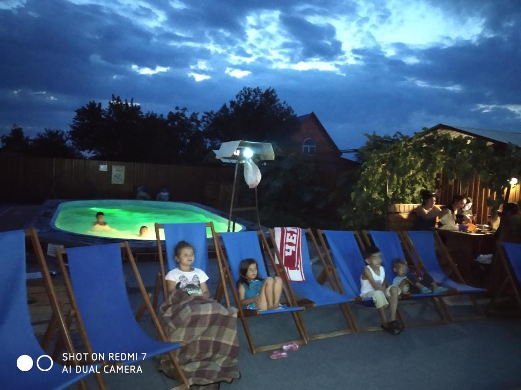 ドルジャンスカヤにあるAzovkiy Bereg 2の子供のグループがプールの前に座って座っている