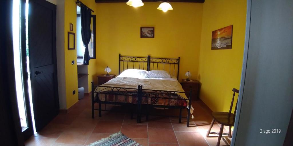 1 dormitorio con 1 cama en una habitación amarilla en IL Borgo 31 en Scapoli