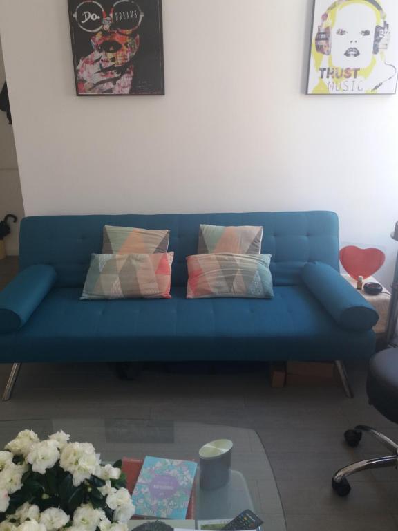 un canapé bleu dans un salon avec une table dans l'établissement Cosy and lovely flat au Port de Nice !, à Nice