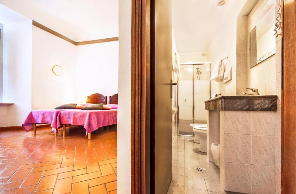 a bathroom with a table with a bed in a room at Hotel Costantini in Florence