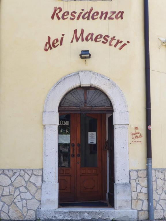 una entrada a un edificio con puerta de madera en Residenza dei Maestri, en Roccaraso