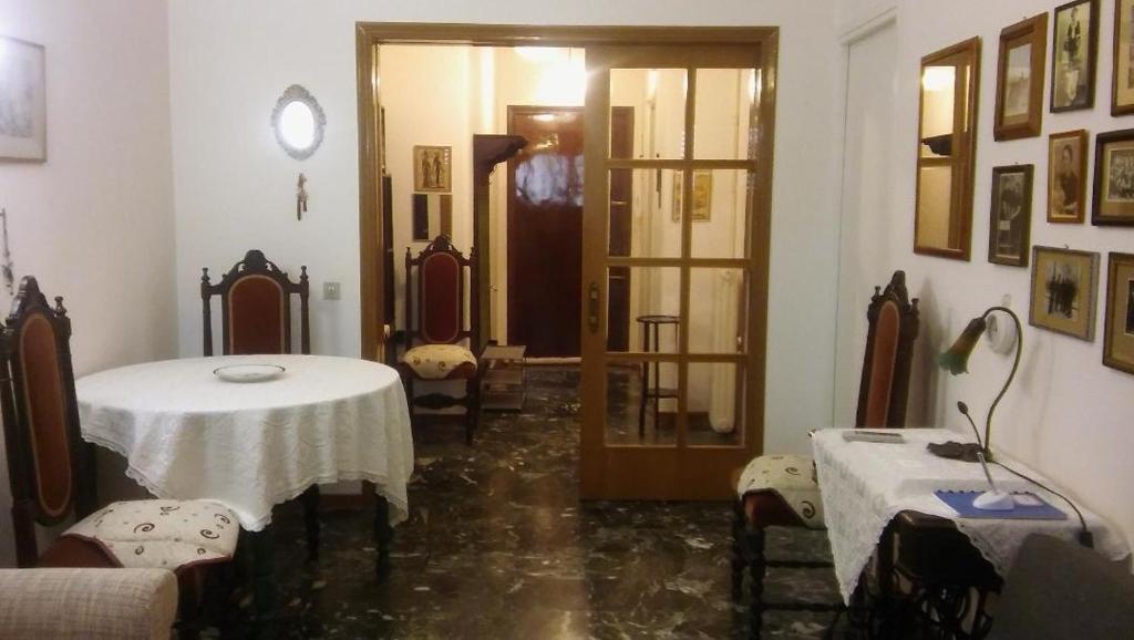 um quarto com uma mesa e cadeiras e uma porta em CHRYSSA - ΧΡΥΣΑ em Patra