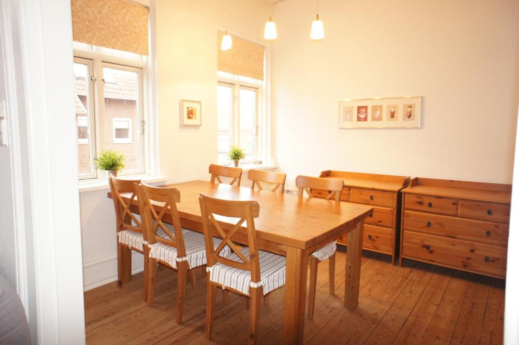 een eetkamer met een houten tafel en stoelen bij id. 061. Jyllandsgade in Esbjerg