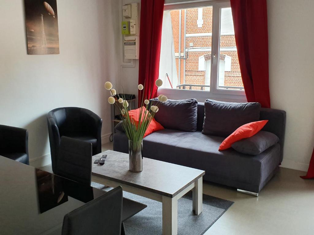 sala de estar con sofá y mesa en Appartement des Remparts, en Valenciennes