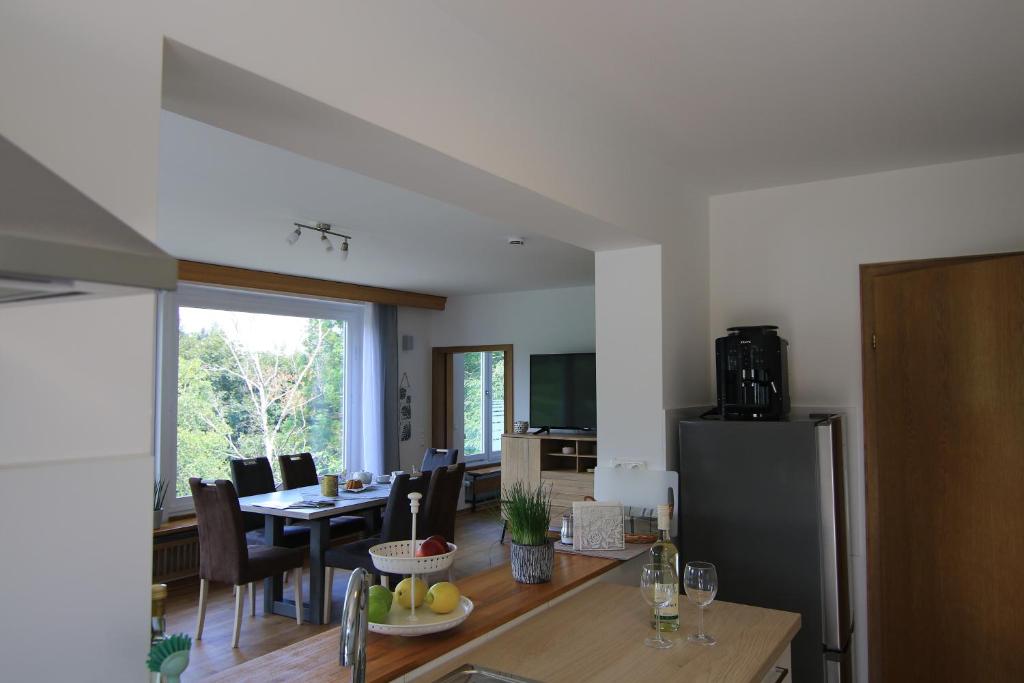 uma cozinha e sala de jantar com uma mesa e um frigorífico em Wohnung Talblick em Schleiden