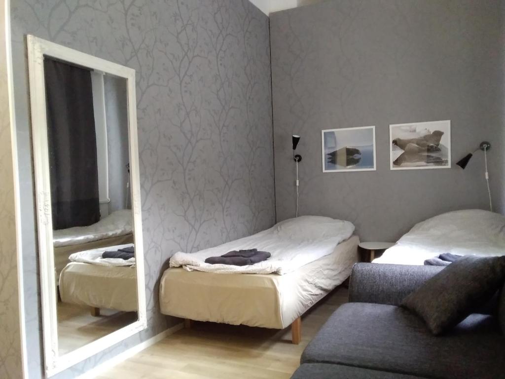 a bedroom with two beds and a mirror at Wanhan Aseman Majatalo in Savonlinna