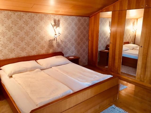 a bedroom with a large bed and a mirror at Haus Edlinger in Hinterstoder
