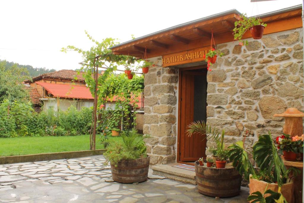 kamienny dom z roślinami przed nim w obiekcie стаи за гости Диневи w mieście Kałofer