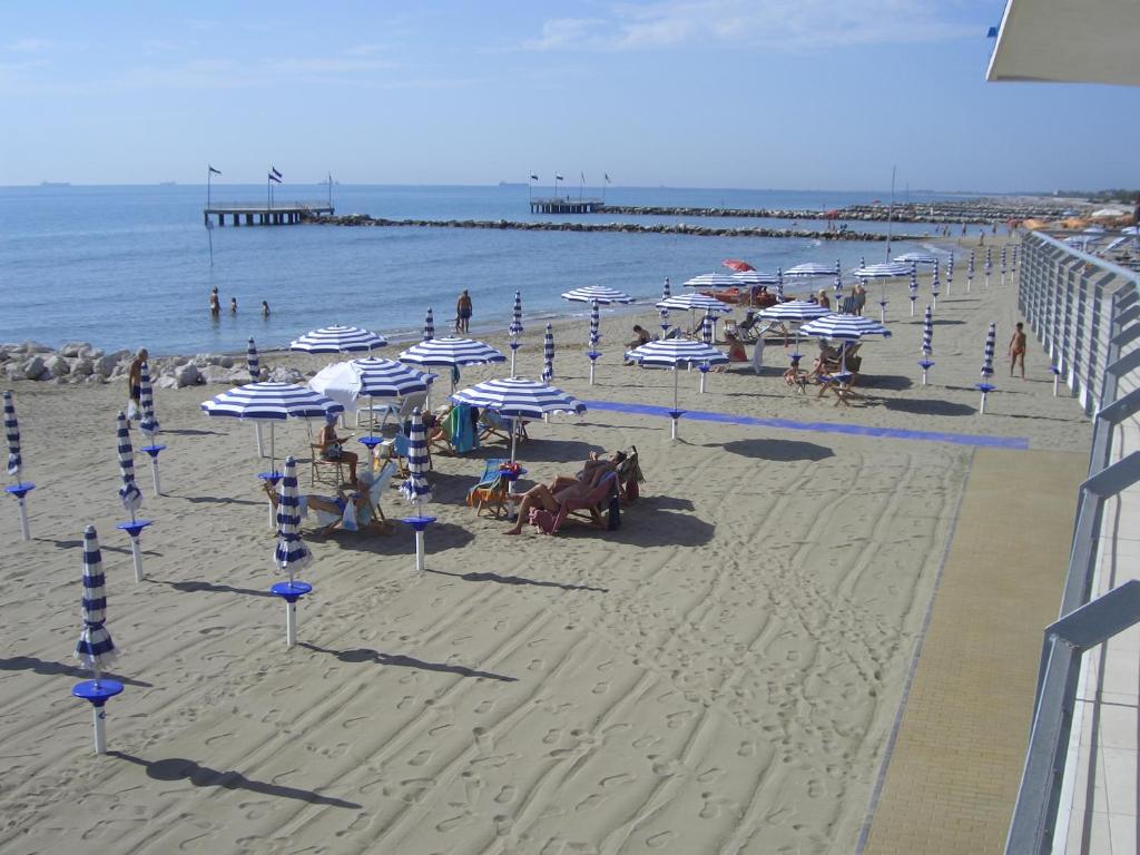 a beach with umbrellas and people on the sand at Hotel Sorriso in Venice-Lido
