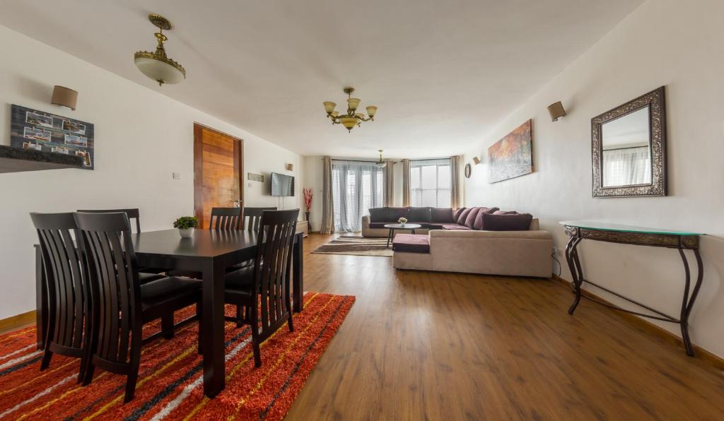a living room with a table and a couch at Erica Residences - Riverside in Nairobi