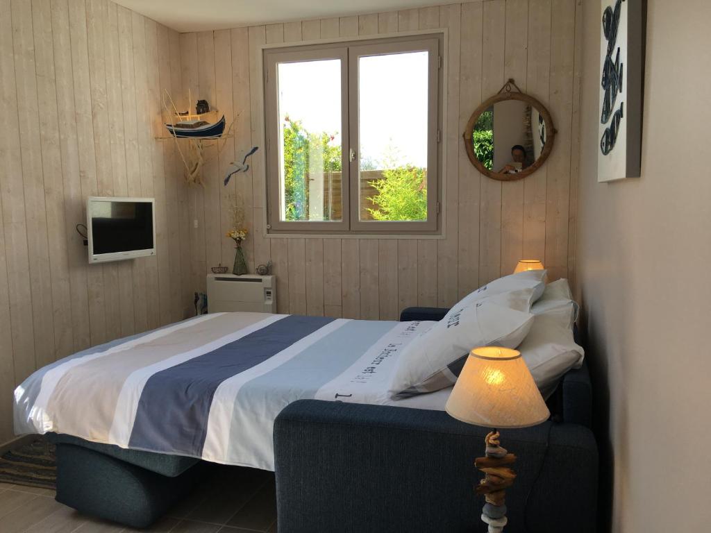 ein Schlafzimmer mit großem Bett und Fenster in der Unterkunft PETIT STUDIO de L'ERMITAGE in Gujan-Mestras
