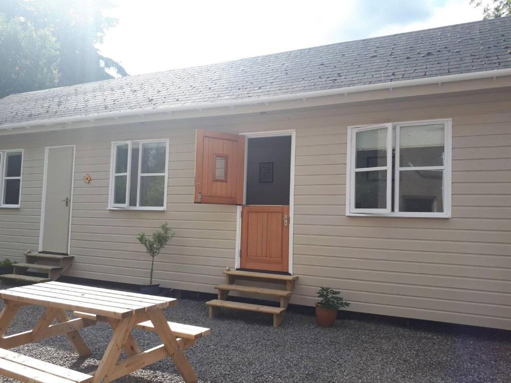 a house with a picnic table in front of it at The Cabin at No 45 in Ballater