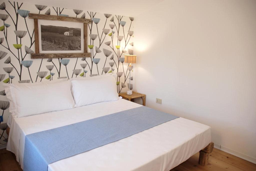 a bedroom with a bed and a picture on the wall at Hotel Galman in Carloforte