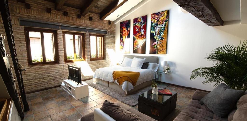ein Schlafzimmer mit einem Bett und einem Sofa in einem Zimmer in der Unterkunft La Morada del Pintor EVI00178 in Laguardia
