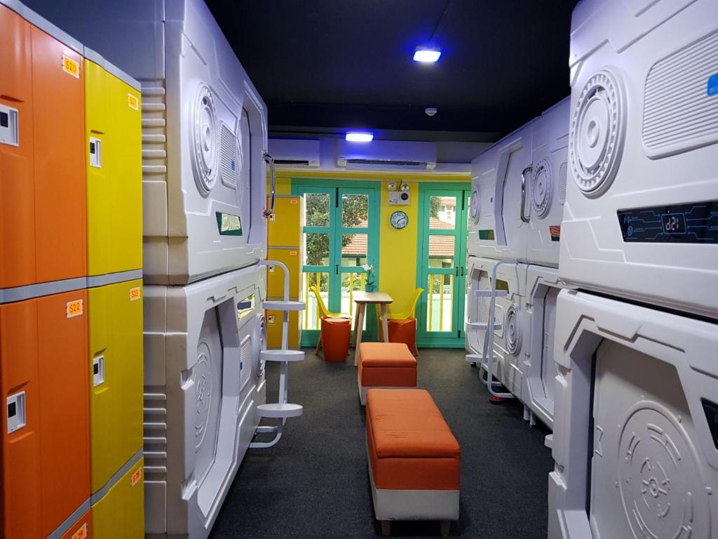 a laundry room with orange chairs and machines at Galaxy Pods @ Chinatown in Singapore