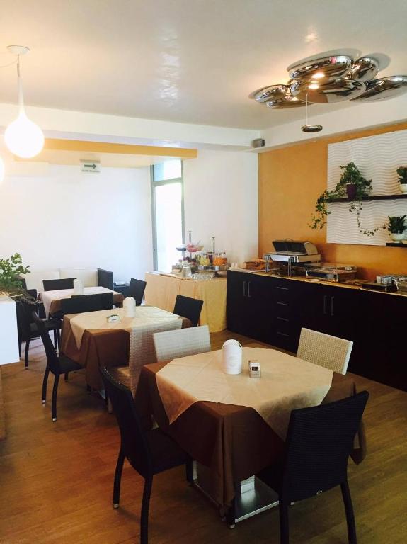 a restaurant with tables and chairs and a kitchen at Santa Caterina Resort in Santa Caterina di Nardò