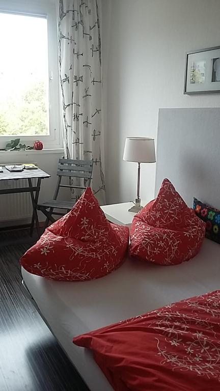 a bedroom with a bed with red pillows on it at Am Goldenen Reiter in Dresden