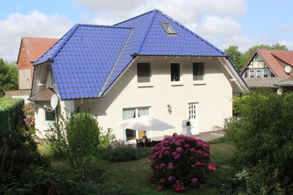 una gran casa blanca con techo azul en Ferienwohnung Holzerland, en Patzig