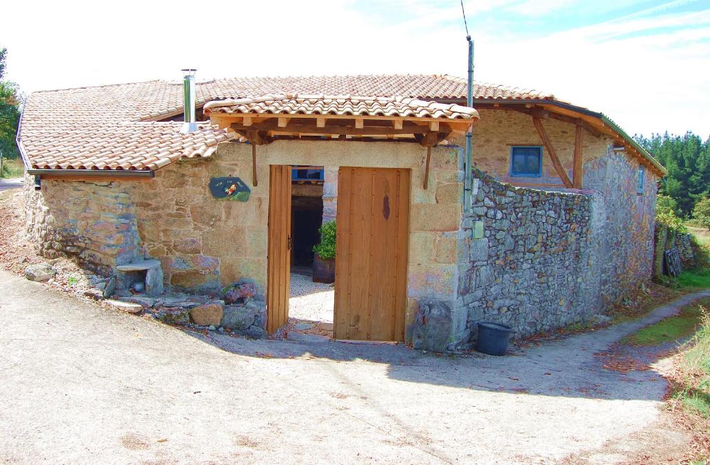 a small stone house with a door on a road at Casa do Polo A Vilerma Ribeira Sacra in Sober