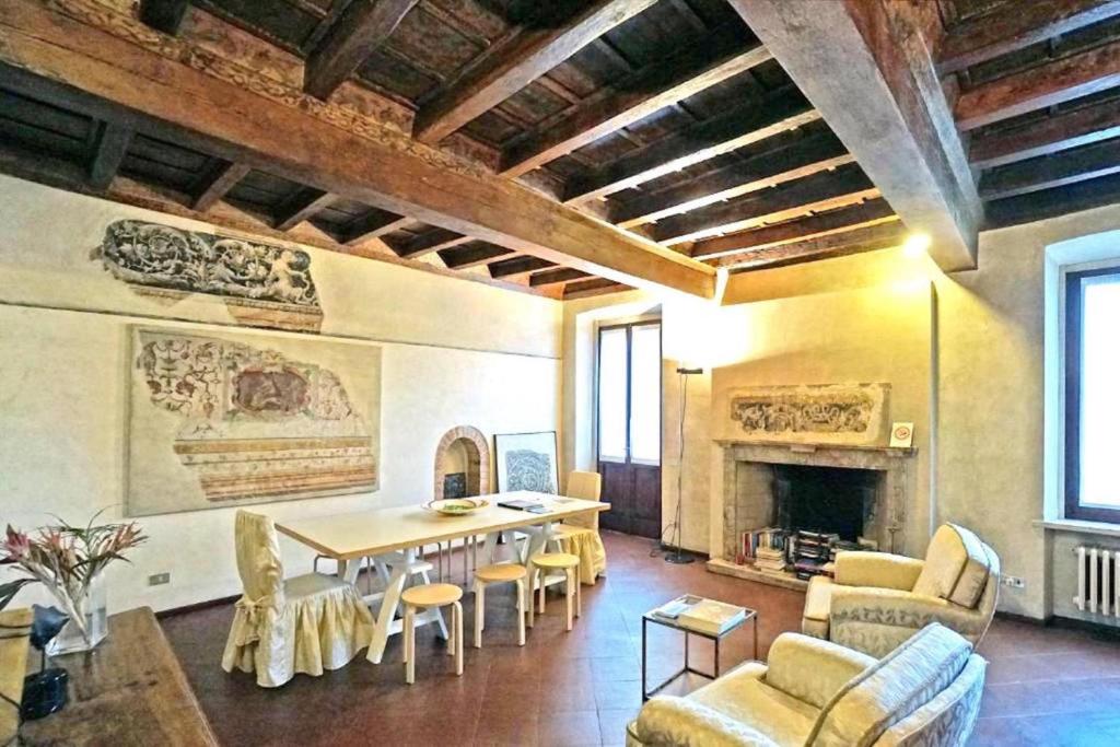 a living room with a table and chairs and a fireplace at Casa del Pittore in Mantova