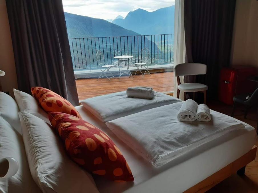een slaapkamer met een bed en een groot raam bij Agriturismo Bio Ca' Pianazòla in Chiavenna