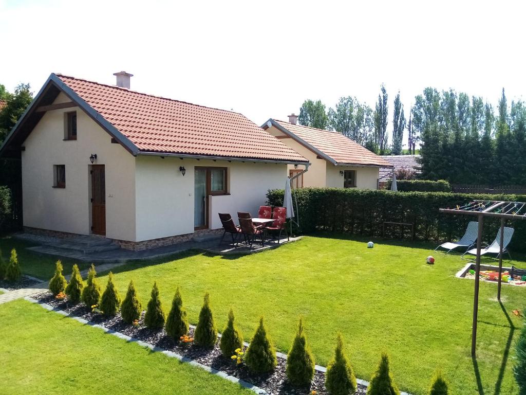 un pequeño patio con una casa blanca con césped en Apartmány Furgalak, en Liptovská Sielnica
