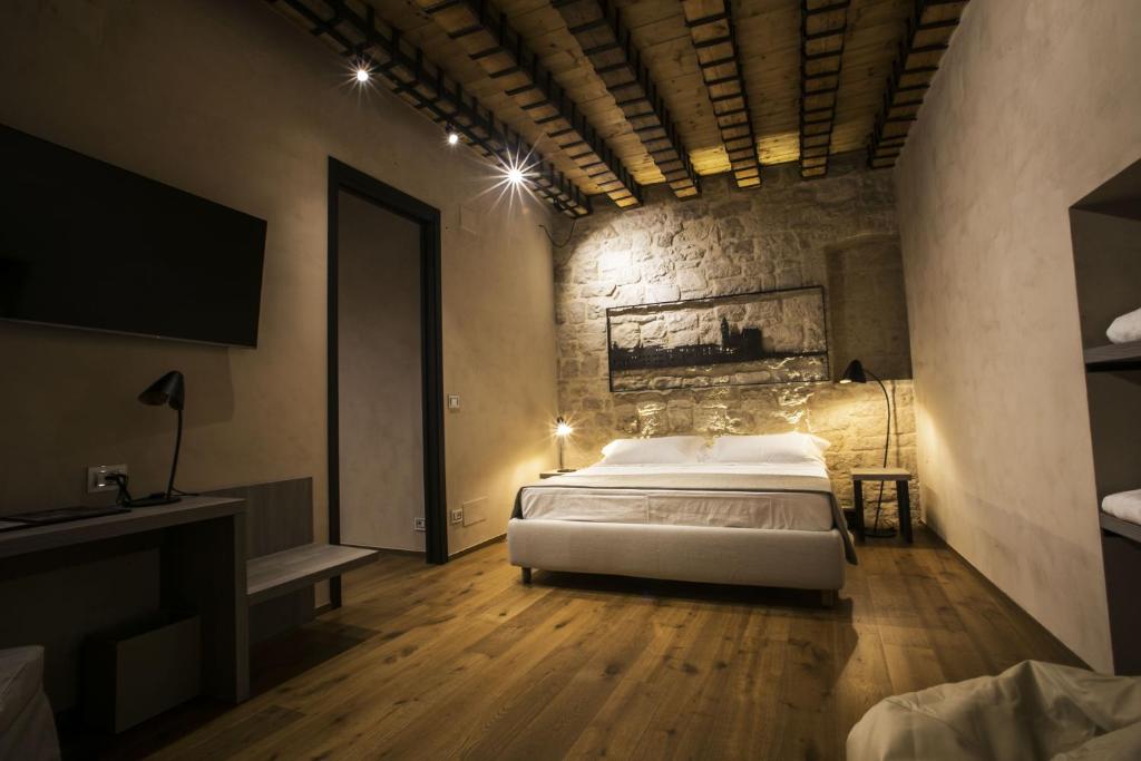 een slaapkamer met een bed en een televisie in een kamer bij Edward Rooms & Wellness B&B in Trani
