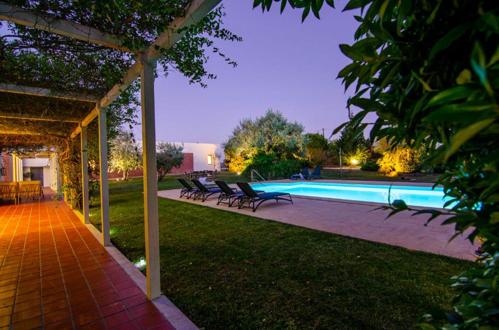 a swimming pool with lounge chairs next to a house at Vale Pisco in Bombarral