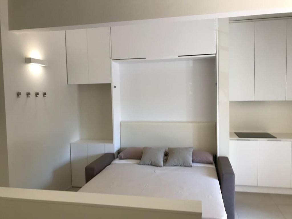 una camera con letto bianco e armadi bianchi di Olivo House 1 a Portovenere