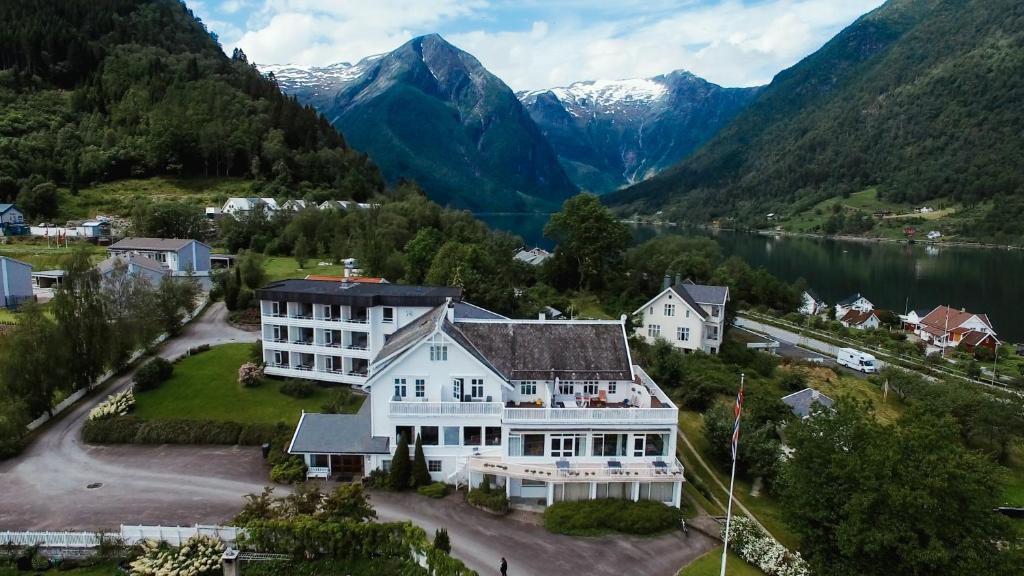 an aerial view of a large white house with mountains at Kringsjå Hotel in Balestrand
