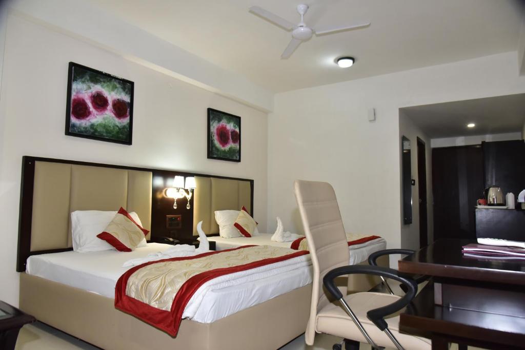 a bedroom with a bed and a desk and a table at Maya Heritage in Bodh Gaya