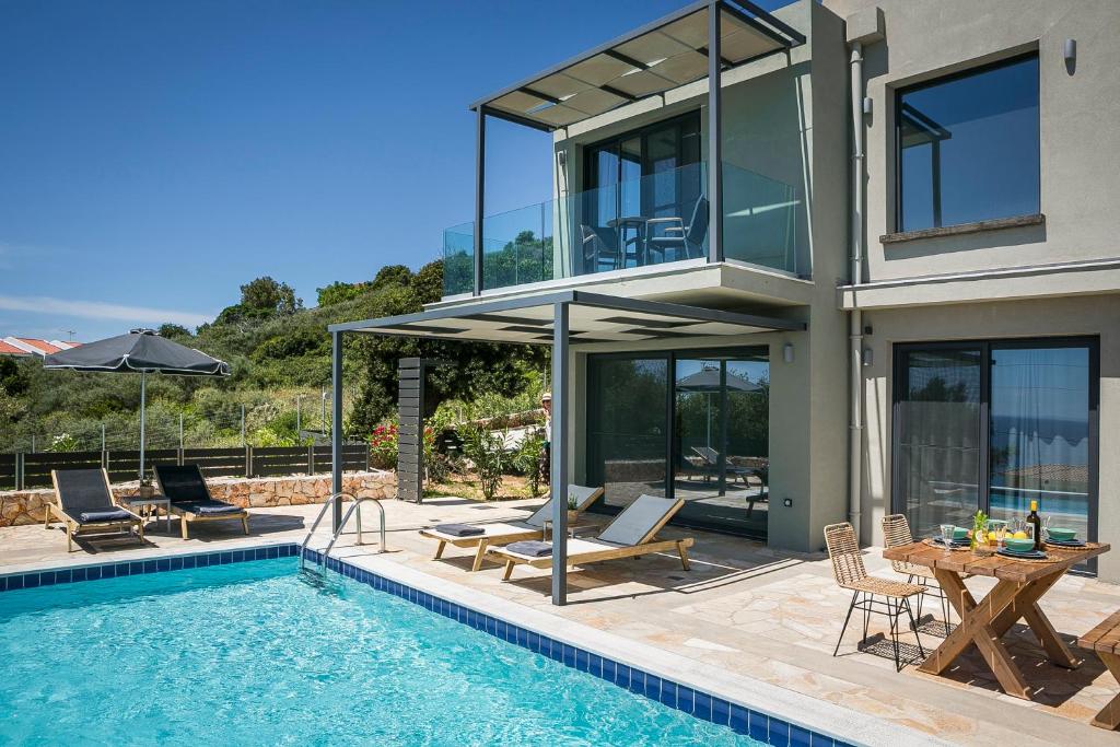 a house with a swimming pool next to a house at Villa Sea front in Spathíon