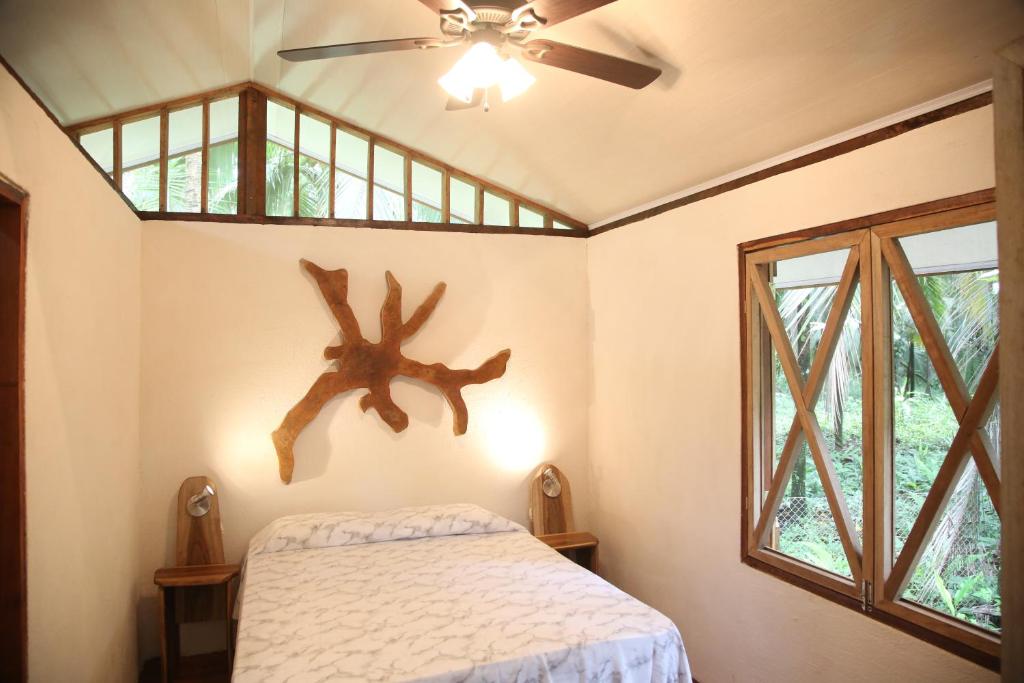 1 dormitorio con 1 cama y ventilador de techo en Caribbean Secret en Cahuita
