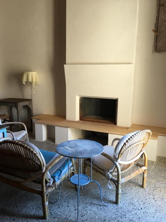 ストロンゴリにあるBORGO PETELIA, "Casa Perri", antica casa ristrutturata con terrazzoのリビングルーム(椅子2脚、テーブル、暖炉付)