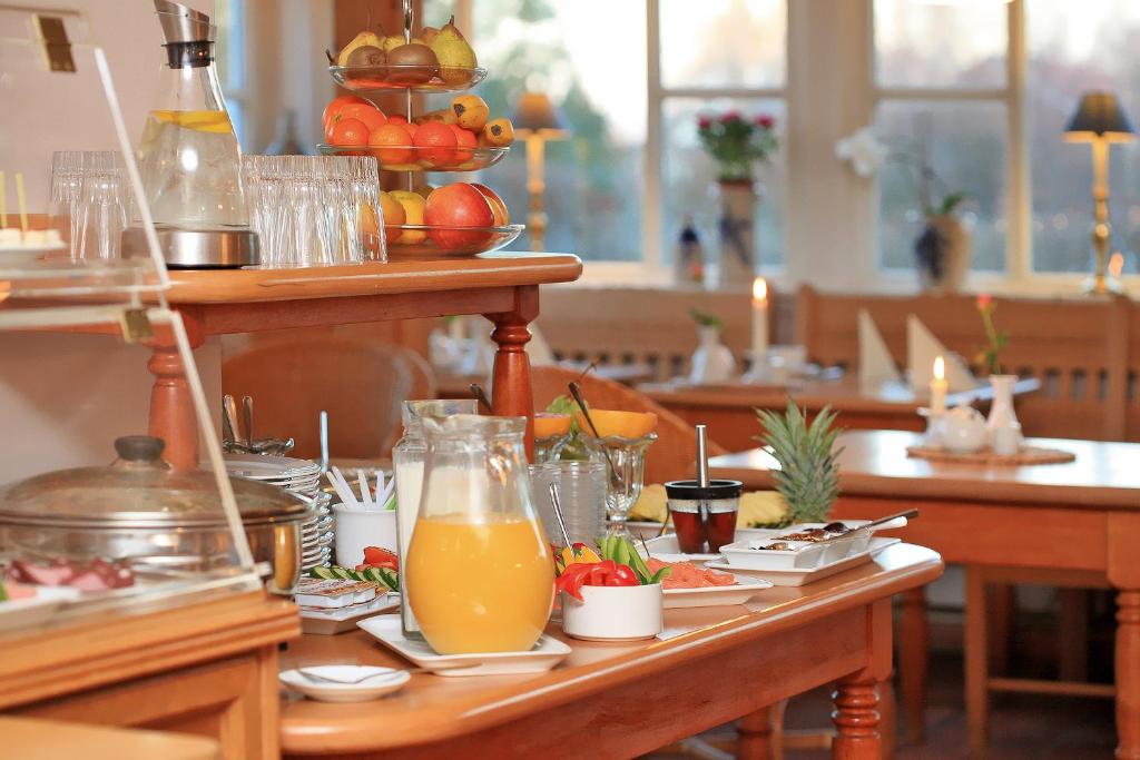 a table with plates of food and orange juice at Landhaus Susewind in Ahrenshoop