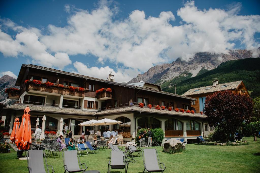 un bâtiment avec des chaises et des personnes devant lui dans l'établissement Hotel Nevada, à Bormio