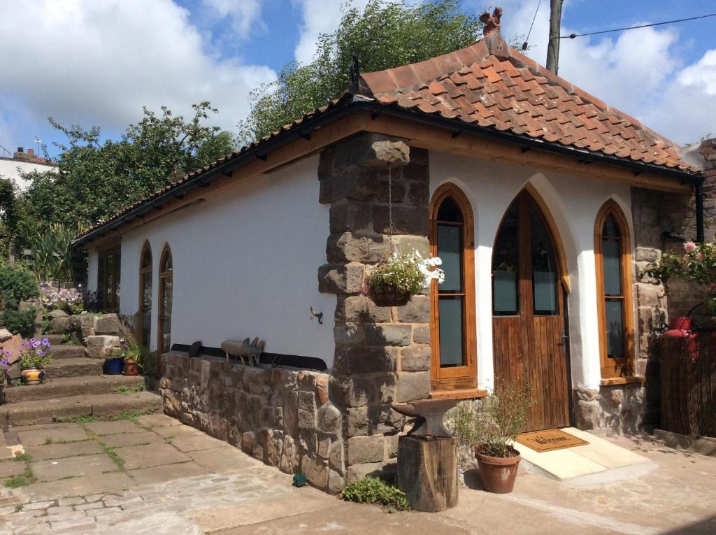 a small stone house with a brown roof at The Hideaway - a charming, unique retreat in Long Ashton, Bristol in Bristol