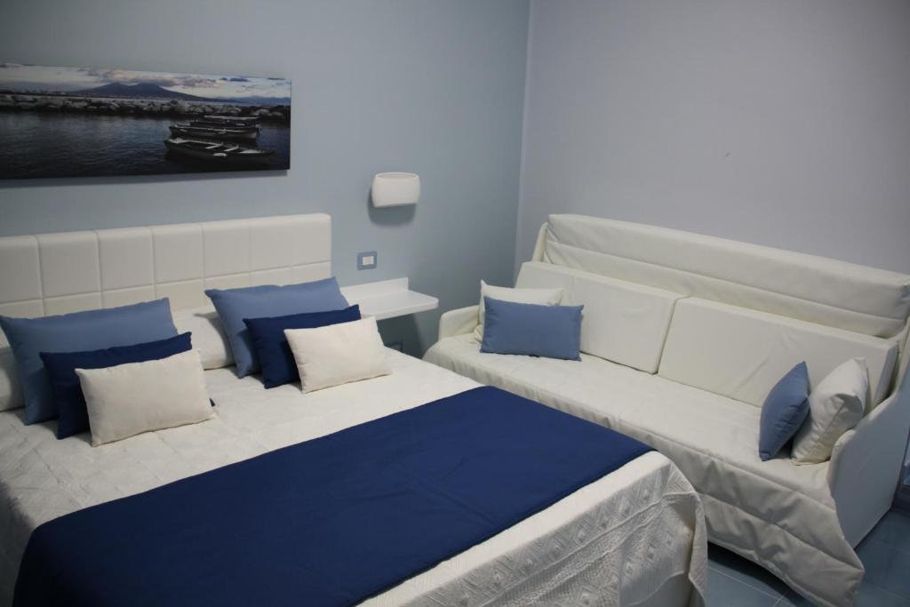 a room with two beds with blue and white pillows at BLU SEA SORRENTO in Sorrento