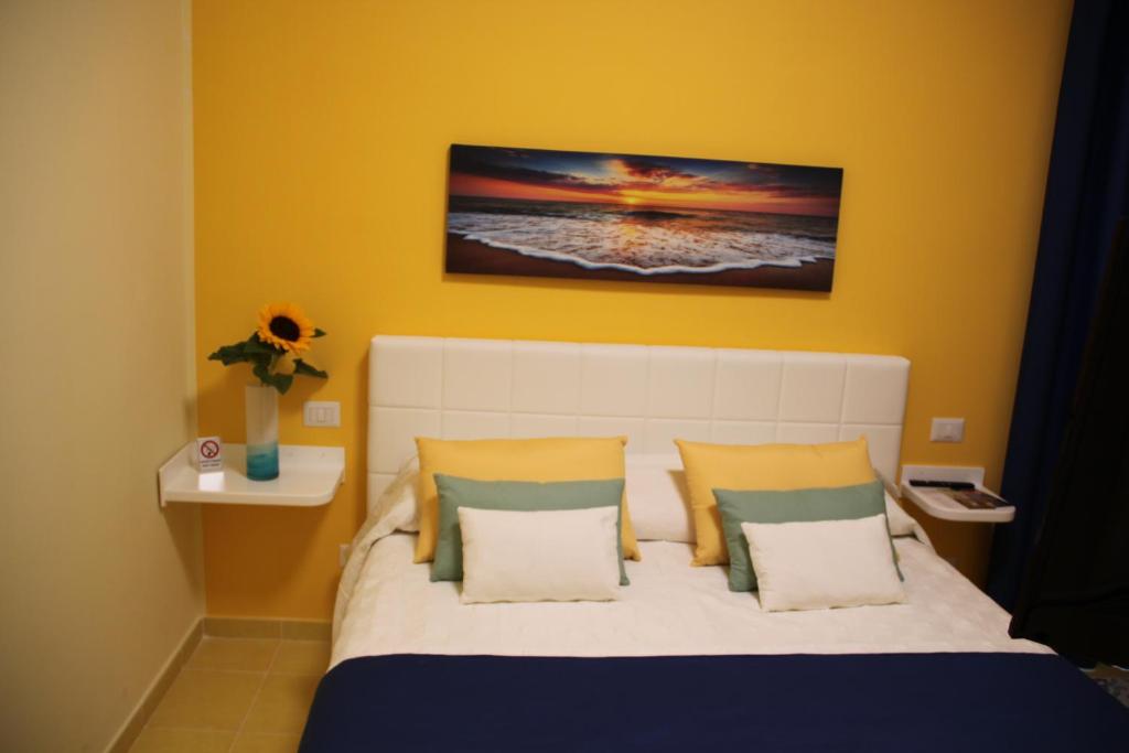 a bedroom with a bed with yellow walls at BLU SEA SORRENTO in Sorrento