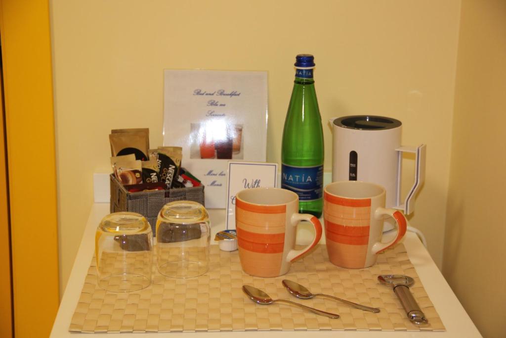 a table with two cups and a bottle of wine at BLU SEA SORRENTO in Sorrento