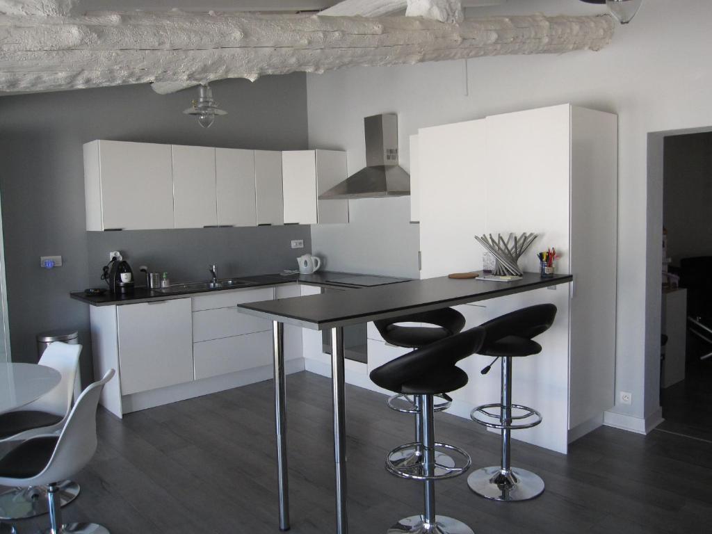 a kitchen with a table and two bar stools at Le Gite de Fanny in Saintes-Maries-de-la-Mer