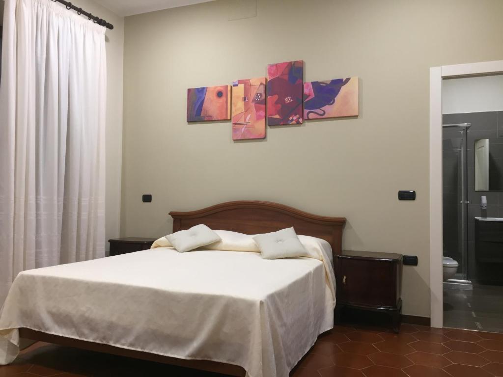 a bedroom with a bed and two paintings on the wall at B&B Duomo Pizzo ApartHotel in Pizzo