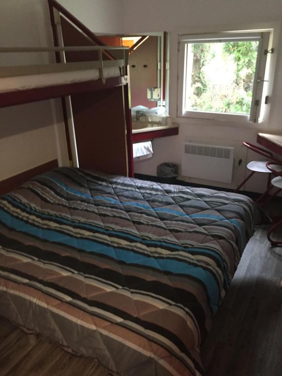 Bett in einem Schlafzimmer mit Etagenbett in der Unterkunft ClassEco Gent in Gent