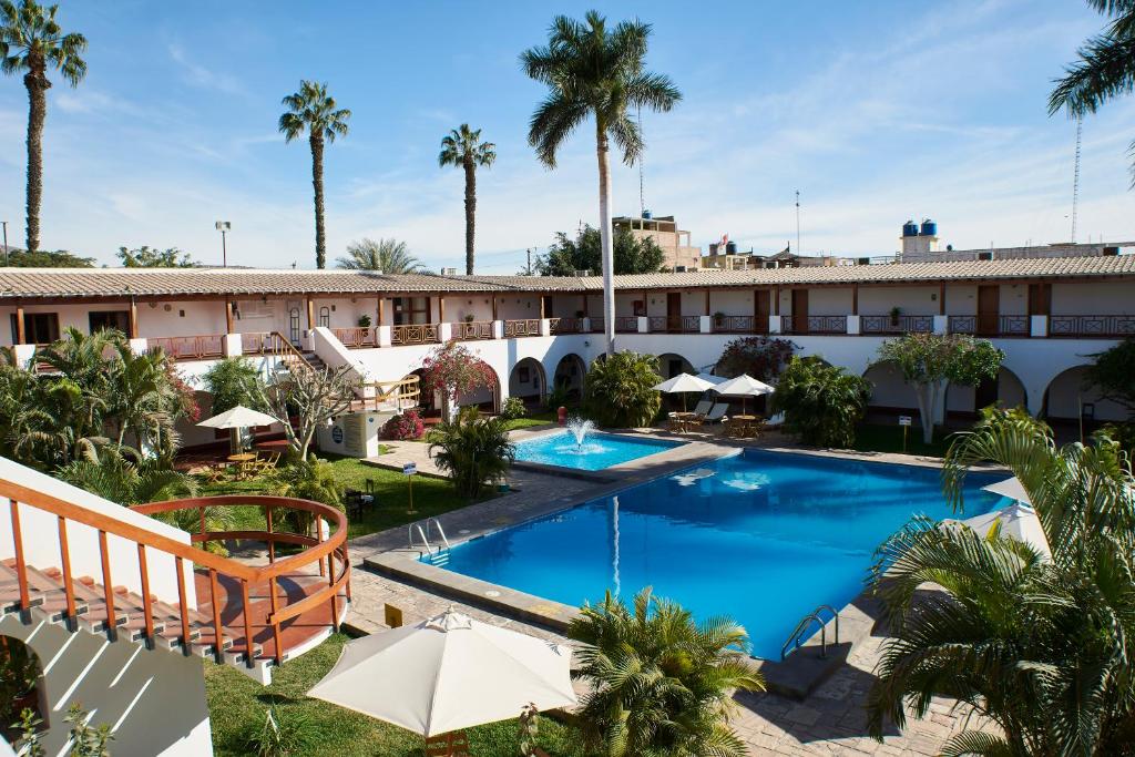 una imagen de un hotel con piscina y palmeras en DM Hoteles Nasca, en Nazca
