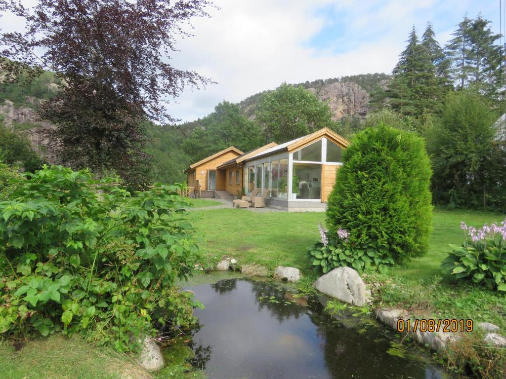 a house with a pond in front of it at Øvstefjellså Gård &Aktivitet Senter in Flekkefjord