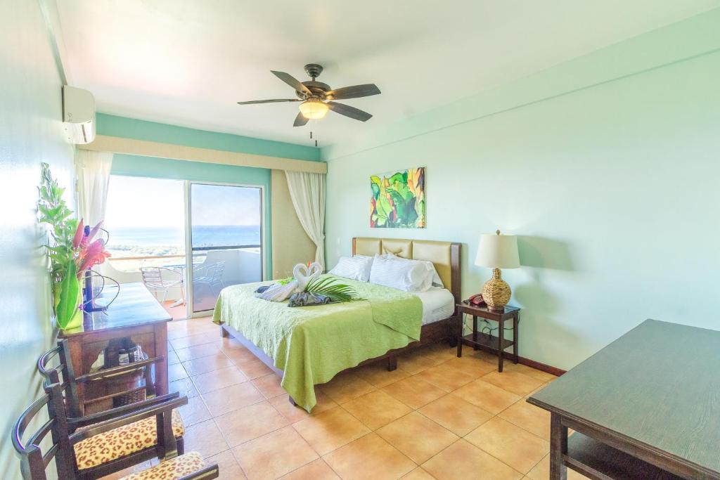 een slaapkamer met een bed en een plafondventilator bij Vista Ballena in Uvita