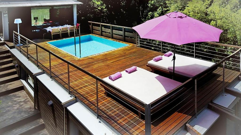 una terraza con sombrilla y piscina en Villa Begur Hideaway con piscina privada, en Begur