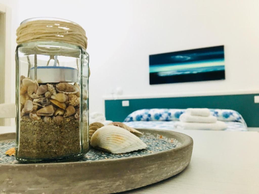 ein Glas voller Steine und eine Schale auf dem Tisch in der Unterkunft ERPI VACANZE DI PALMATE' CINZIA in San Pietro in Bevagna