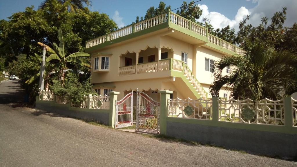 una casa con una puerta y una valla en Fairy Hill Palms, en Port Antonio